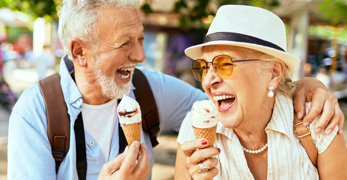senior couple enjoying ice cream and laughing by Ana Correa