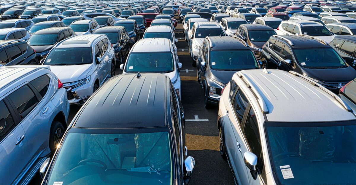 Rows of many contemporary expensive automobiles parked on asphalt of manufacture in daytime
