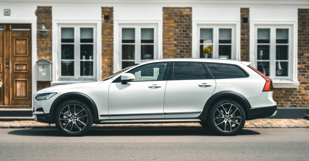 a white volvo car parked in front of a house