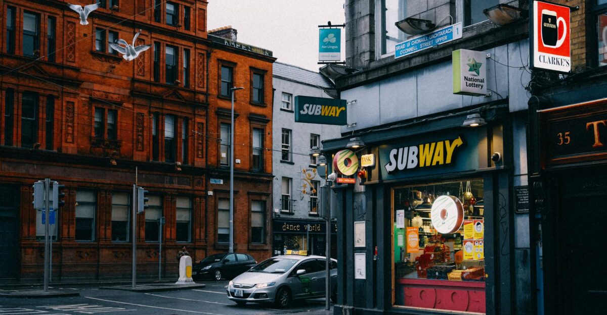 Busy urban street with Subway shop and historic architecture