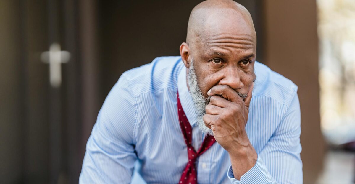 Thoughtful middle-aged man in business attire sitting outdoors pondering solutions to a problem