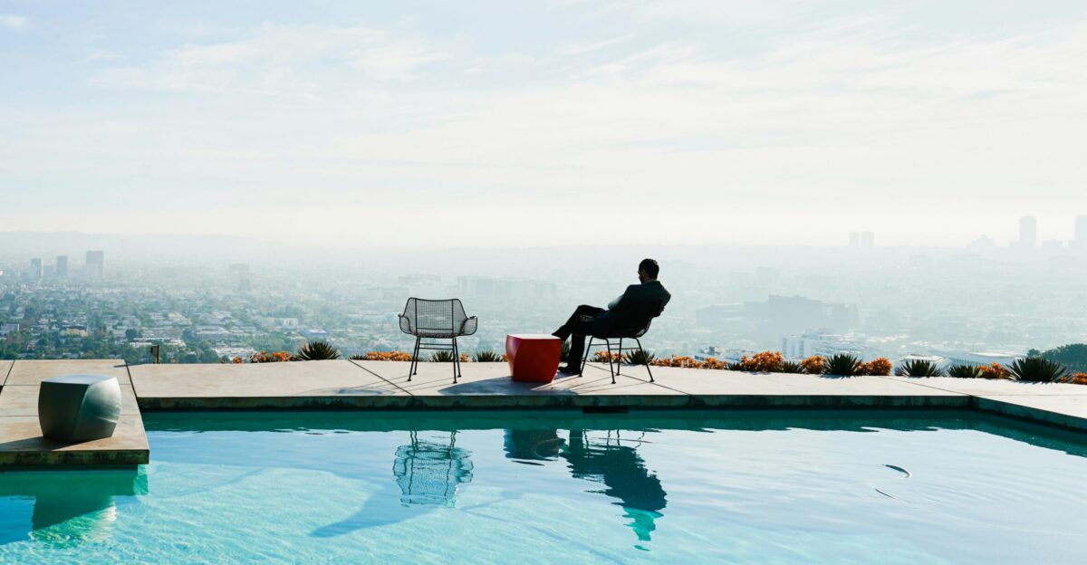 a person sitting in a chair by a pool