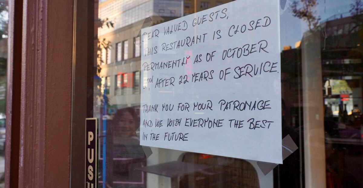 A sign posted on the door of a restaurant