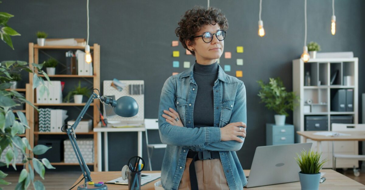 Woman standing with arms crossed in modern office