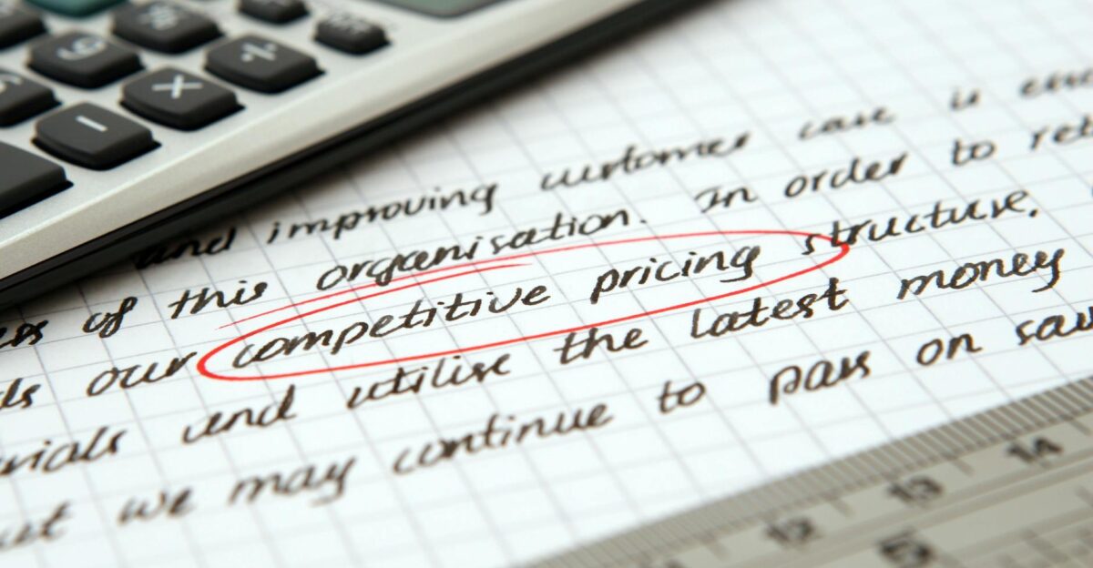 Focused image of handwritten business notes with calculator emphasizing pricing strategy