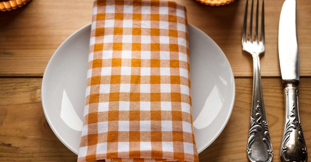 Close-up of a stylish dining table setting with a gingham napkin