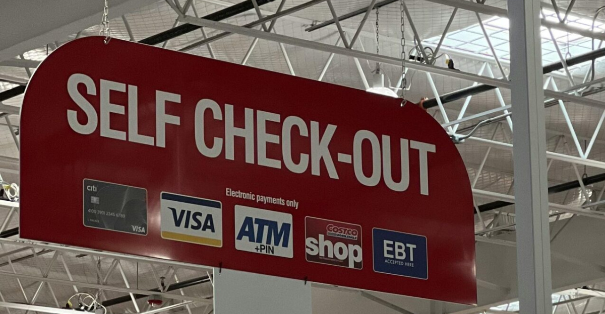 Self check-out section in a large warehouse store with visible payment options.