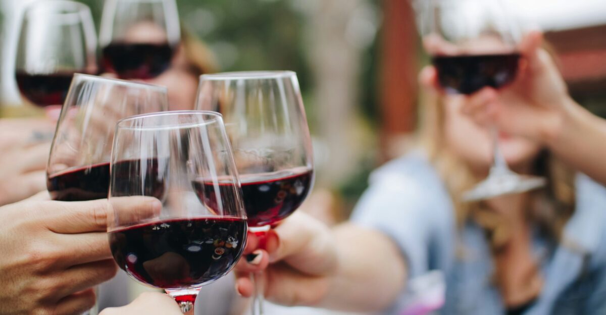 people tossing their clear wine glasses