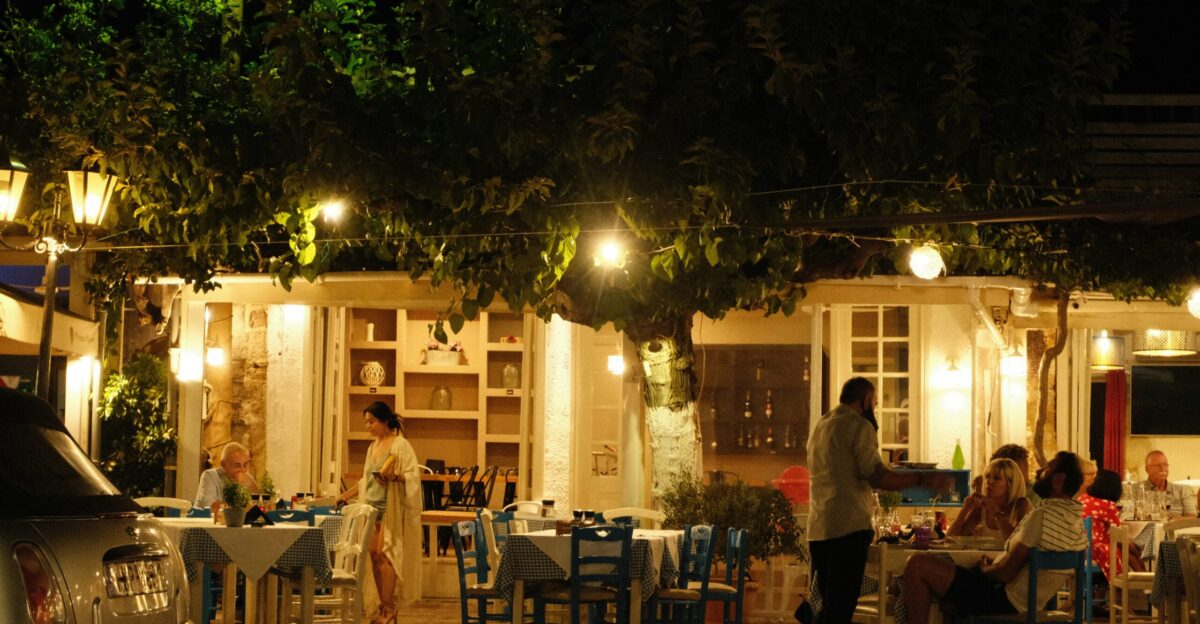 a group of people sitting at a table outside of a restaurant