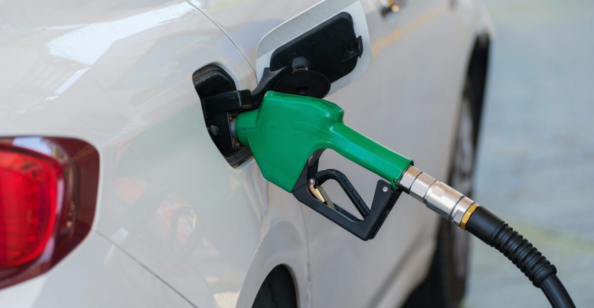 a white car with a green gas pump