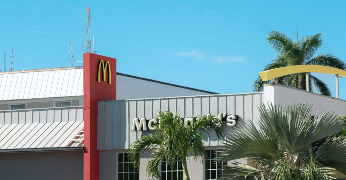 a mcdonald s restaurant with palm trees in front of it