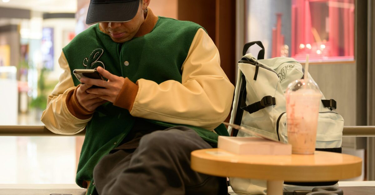 A man sitting on a bench looking at his cell phone