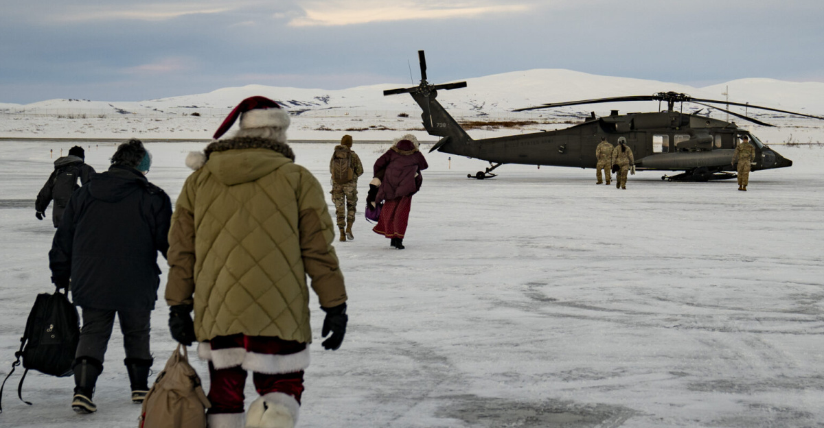 Santa, Mrs. Claus and Operation Santa Claus volunteers prepare to board an Alaska Army National Guard UH-60L Black Hawk helicopter in Nome, Alaska, Nov. 30, 2023. From Nome, the journey continued 70 miles east via UH-60L Black Hawk helicopter to the Inupiat Eskimo village of Golovin. Operation Santa Claus is the Alaska National Guard’s yearly community outreach program that provides gifts and Christmas cheer to children in remote communities across the state. (Alaska National Guard photo by Dana Rosso)