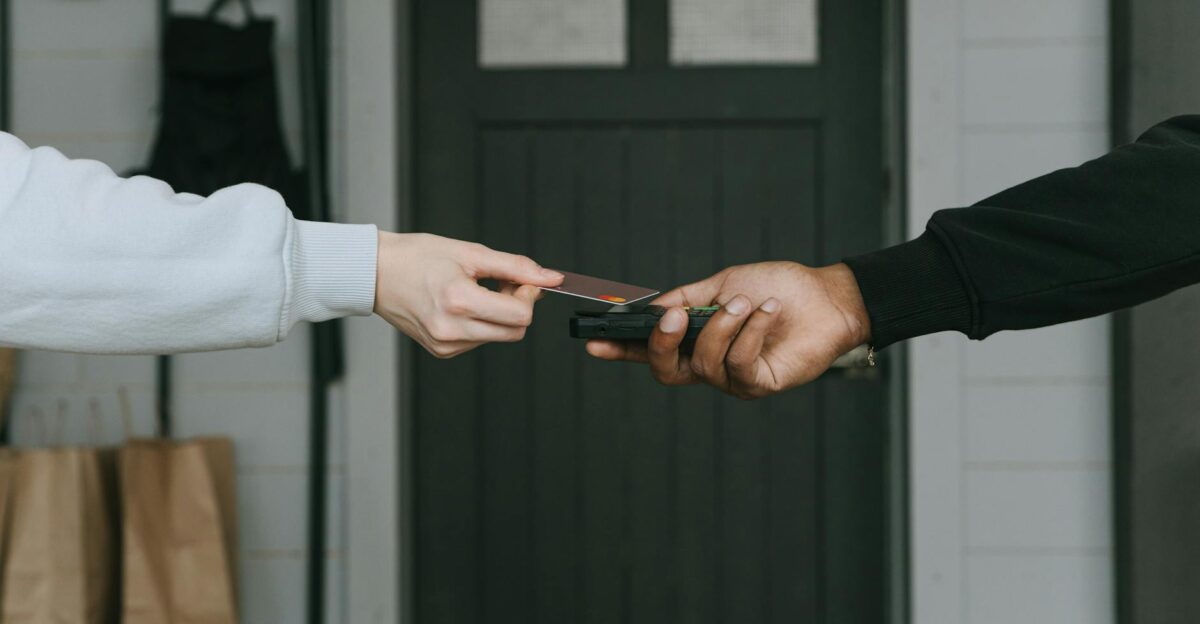 Close-up of hands making a contactless card payment indoors highlighting cashless transaction technology