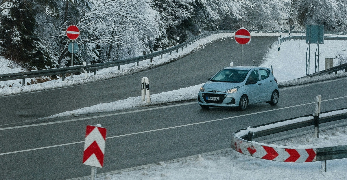 A car is driving down a snowy road