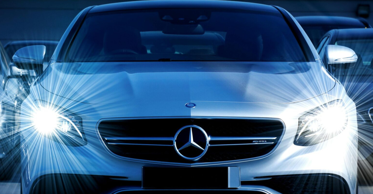 Front view of a lineup of Mercedes-Benz cars with bright headlights, showcasing luxury and elegance.