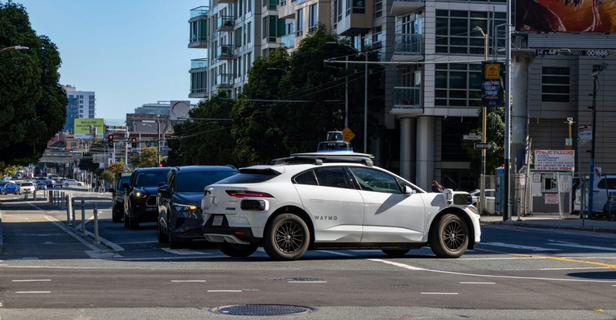 A white car is stopped at an intersection